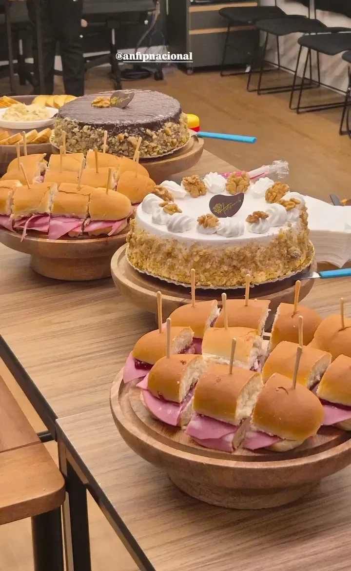 Mesa de coffee break com sanduíches e bolo