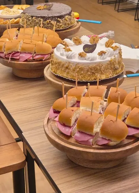 Mesa de coffee break com sanduíches e bolo